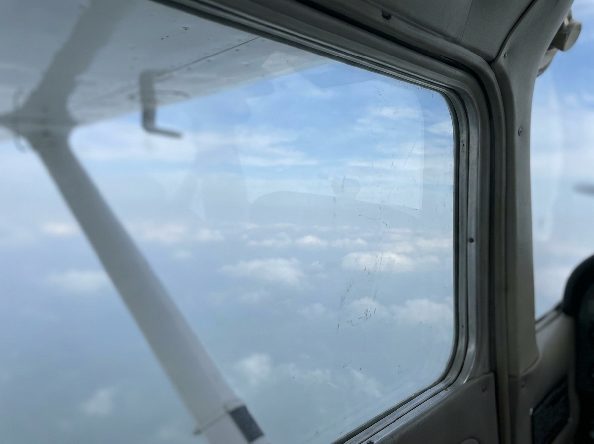 Aircraft wing edge beneath a pale sky.